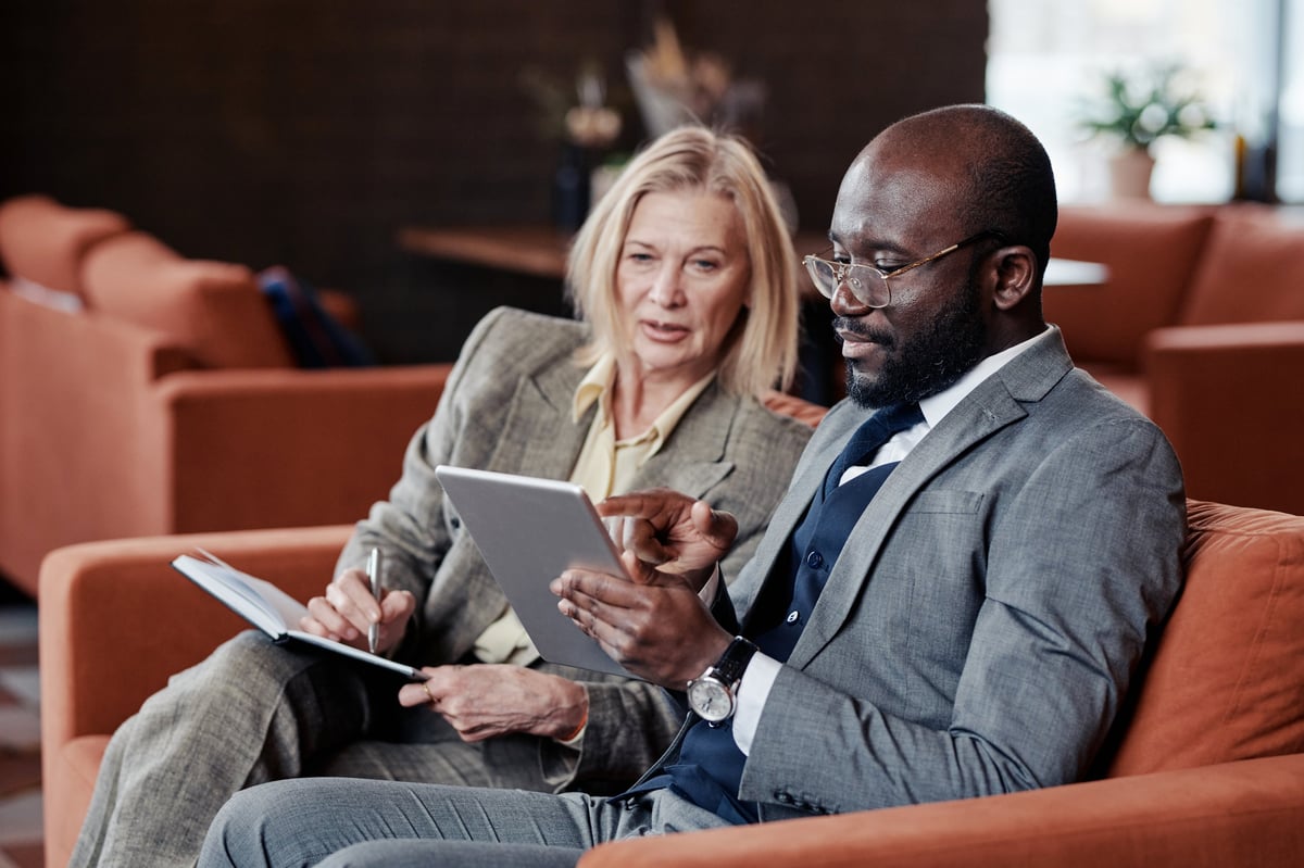 Business consultant and client reviewing a plan on a tablet